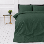 Lniana pościel "Linen Dark Green". Pościel 150x200, 140x200 cm, 150x200 cm, 160x200 cm, 180x200 cm, 200x200 cm, 200x220 cm, 220x240 cm. Ciemnozielony lniany zestaw pościeli na białej podłodze z szafką nocną i rośliną doniczkową.